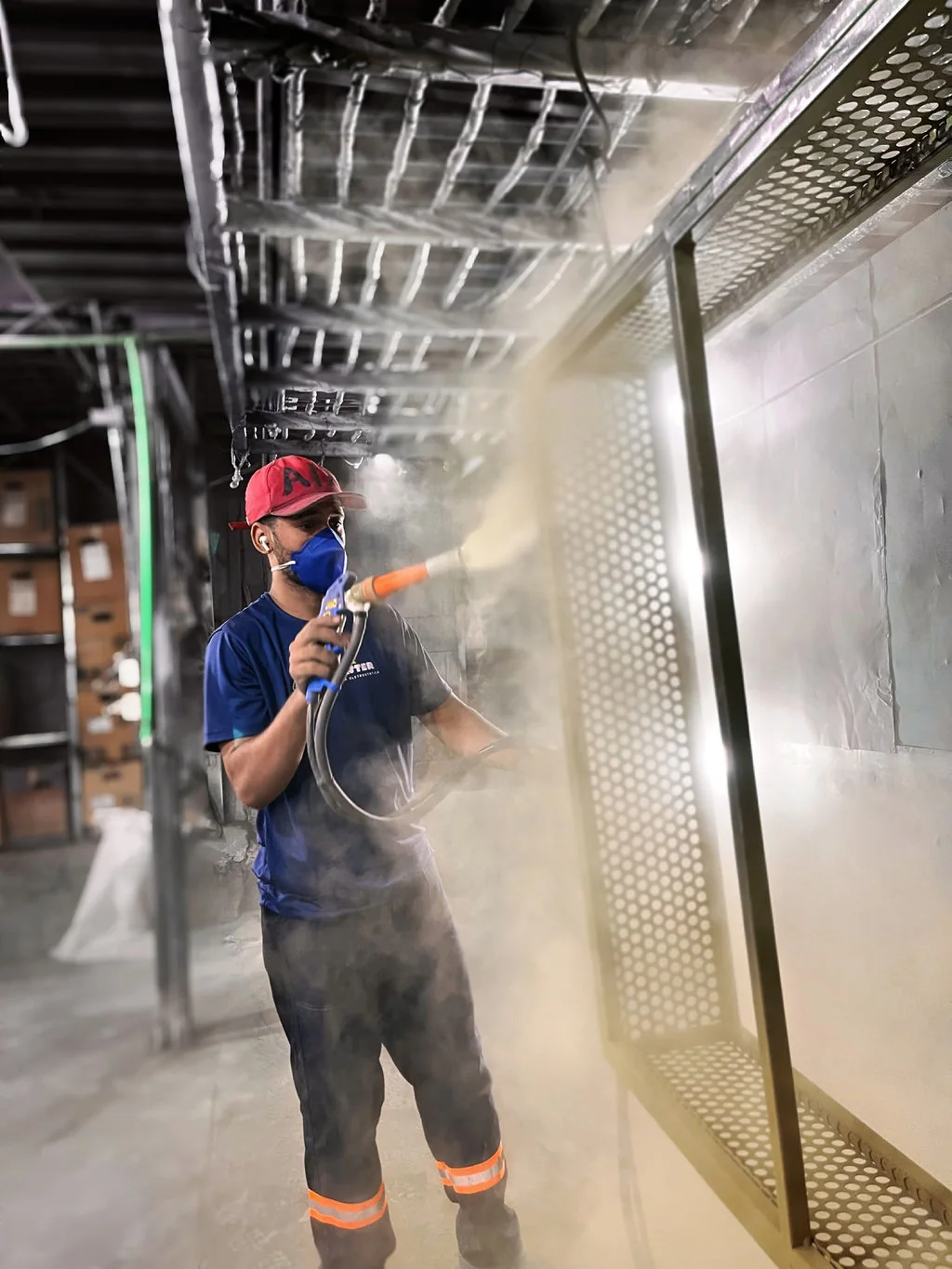 Profissional da Max Master aplicando tinta em um painel metálico