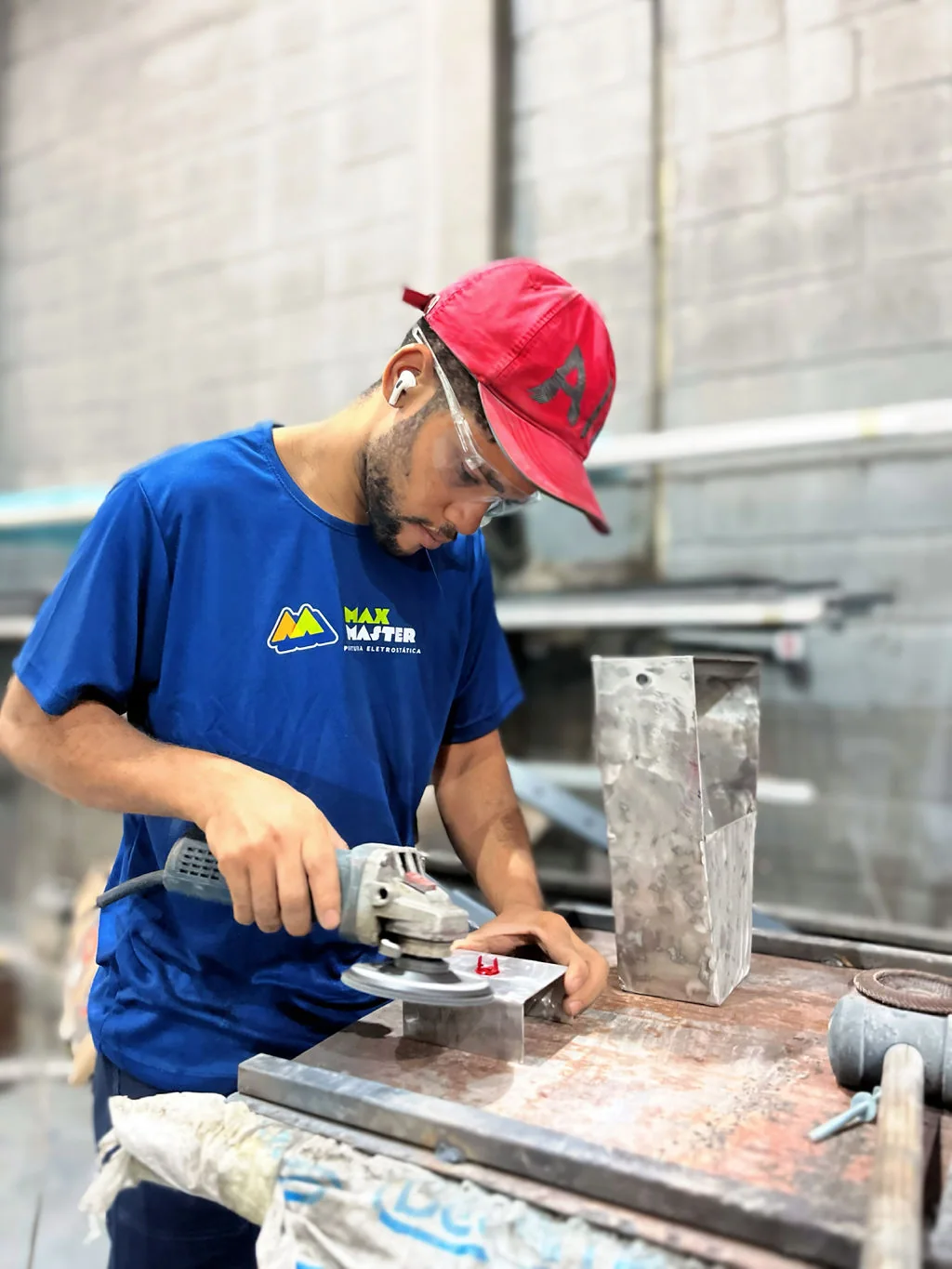 Profissional da Max Master preparando uma peça metálica com ferramenta elétrica
